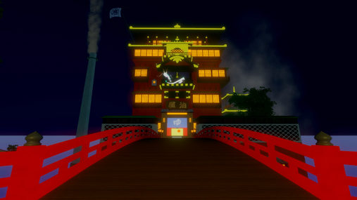 The iconic bathhouse from “Spirited Away,” glowing brightly at night as seen from the red bridge.